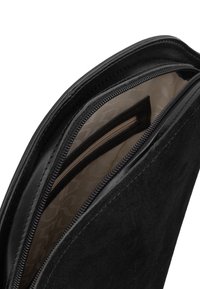 Borsa in pelle nera con una texture liscia, dotata di chiusura con cerniera e fodera interna beige con dettagli di pattern discreti.