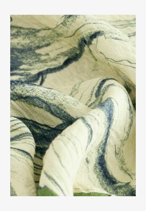 Cotton fabric with abstract green and blue marbled patterns on a light beige background, featuring a soft, textured drape.