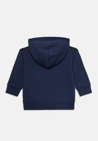 Sudadera con capucha de color azul marino que presenta mangas largas, puños acanalados y una textura suave. La capucha es redondeada y sin costuras en la parte posterior.