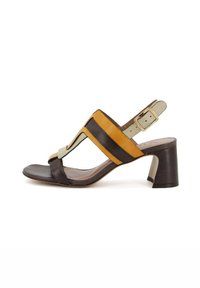 Sandalo in pelle marrone e giallo con tacco blocco, dotato di un design a fascia larga, fibbia alla caviglia regolabile e una superficie liscia.