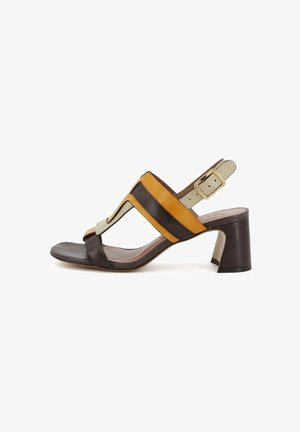 Sandalo in pelle marrone e giallo con tacco blocco, dotato di un design a fascia larga, fibbia alla caviglia regolabile e una superficie liscia.