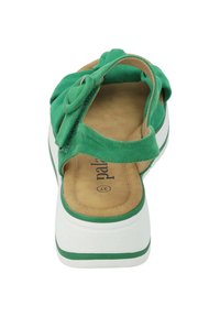Sandalo verde in suede con design della fascia annodata, soletta beige imbottita, suola piattaforma bianca con rifinitura verde e parte posteriore aperta.