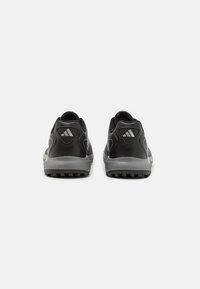 Zapatillas deportivas negras con una superficie texturizada, que presentan acentos grises, un talón acolchado y una suela con diseño para mayor tracción.