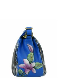 Blaue Lederbörse mit einer bemalten pinken Blume und grünen Blättern auf einer Seite, während die gegenüberliegende Seite ein strukturiertes schwarzes Detail aufweist.