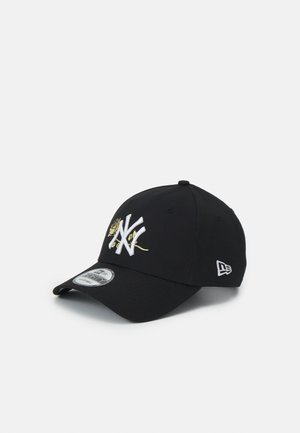 Gorra de béisbol negra con logo "NY" bordado en blanco y detalle floral dorado, mostrada sobre un fondo claro y liso.