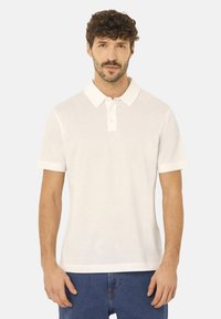 Bílá bavlněná polo košile s krátkými rukávy, s dvouknoflíkovým zapínáním a límečkem. Jednoduchý design, hladká textura a volný střih.