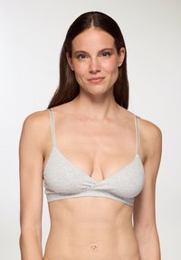 Bralette grigia in cotone con design a V, dotata di spalline regolabili e dettaglio frontale attorcigliato. Texture morbida, stile minimalista.