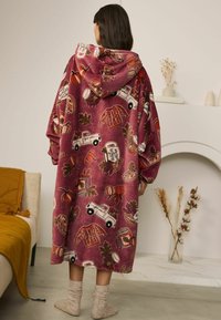 Oversized capuchondeken van bordeauxrood fleece, met herfstthema prints van vrachtwagens, pompoenen en truien in verschillende kleuren en texturen.