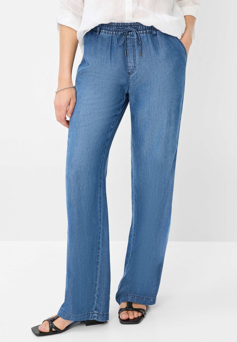 Pantalons en denim bleu clair avec une coupe décontractée à jambes larges. Comprend une taille élastique avec cordon de serrage et des poches latérales.