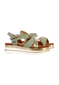 Sandalette mit grünem Obermaterial und metallic goldenen Akzenten. Verfügt über einen Keilabsatz, weißen Sohlen und verstellbaren Knöchelriemchen.