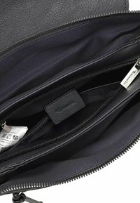 Interno di una borsa in pelle nera con due scomparti con cerniera, rivestimento testurizzato, un piccolo etichetta e lievi dettagli in tessuto.