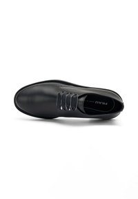 Scarpa in pelle nera con punta arrotondata e cuciture sottili. Presenta lacci elastici e una texture liscia. Suola progettata per la durata.