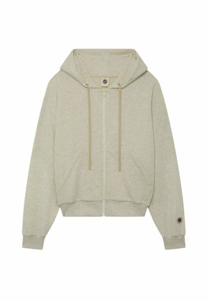 Sweat à capuche zippé beige clair avec cordons, poches avant, poignets côtelés, et un petit patch circulaire sur la manche gauche près du poignet.