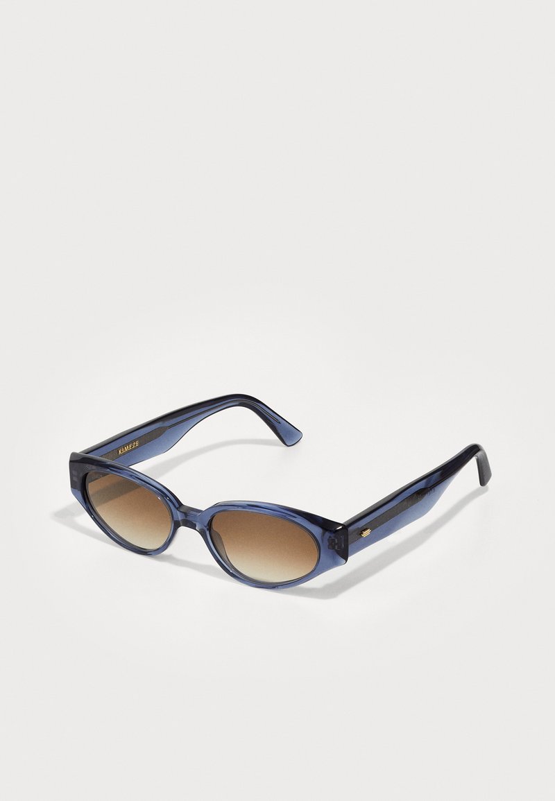 Sinine tooni prillid ovaalsete läätsedega, pruunide gradueerumisega toon, paksud raamid ning peen kullatoon temple.