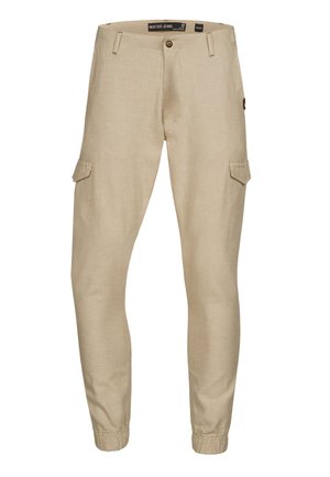 Pantalones cargo beige con puños elásticos, hechos de material ligero. Cuenta con dos bolsillos laterales y un cierre de botón en la cintura.