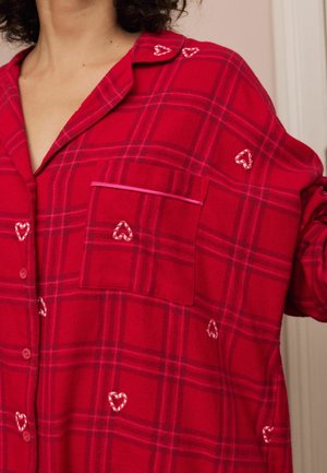 Roter karierter Flanellhemd mit einer Tasche, herzförmiger Stickerei und kontrastierendem Piping. Hemd mit Knopfleiste im lässigen Schnitt und weicher Textur.