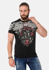 Schwarzes Kurzarm-T-Shirt mit einem auffälligen Grafikdesign in Weiß und Rot, verziert mit floralen Mustern und strukturierten Akzenten im Brustbereich.