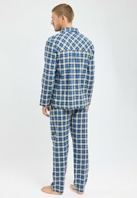 Ensemble de pyjama pour homme en coton, bleu, blanc et jaune à carreaux, comprenant une chemise à boutons et un pantalon ample. Présente un motif à carreaux classique.
