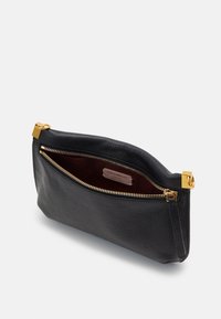 Clutch in pelle nera con finitura texturizzata, zip in oro e un ampio interno. Presenta un'etichetta in pelle con il marchio all'interno.