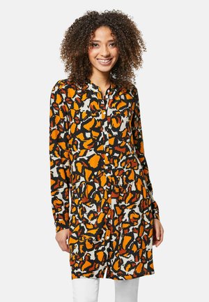Langarm jurk in oranje, zwart en crèmekleurig abstract patroon; lichte stof, knoopsluiting aan de voorkant, met een gathered taille en zakken.