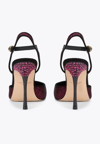 Sandali neri con tacco alto decorati con cristalli rosa sul retro. Presentano una cinghia alla caviglia regolabile e un elegante tacco a stiletto.