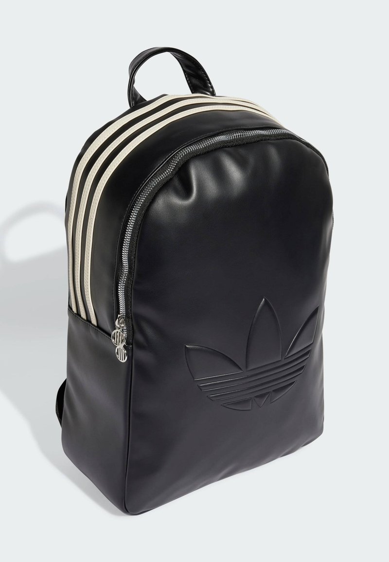 Sac à dos noir en simili cuir lisse, avec trois accents à rayures beiges, un logo texturé à l'avant et une poche zippée.