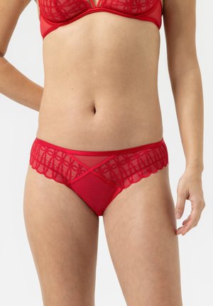 Rote Unterwäsche aus einer Mischung aus transparenter Spitze und weichem Stoff, mit gewellten Kanten und geometrischen Mustern auf der Vorderseite.