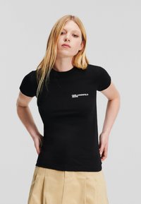T-shirt nera aderente con maniche corte, con logo bianco "Karl Lagerfeld Jeans" sul petto. Tessuto morbido, design semplice.