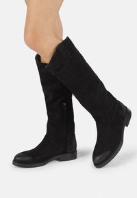 Botas de ante negras hasta la rodilla con punta redonda y detalles de cuero liso, que cuentan con una cremallera lateral y un tacón bajo apilado.