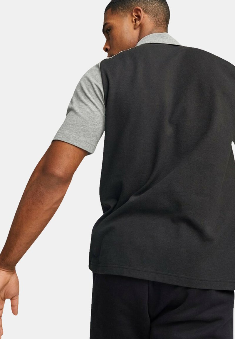 Polo a maniche corte con corpo nero e colletto grigio. Realizzato in tessuto testurizzato, con una vestibilità comoda e dettagli delle cuciture sottili.