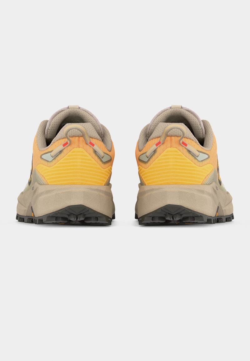 Par de zapatillas para correr por senderos en colores naranja y beige, vistas desde atrás mostrando cuellos acolchados, lengüetas para tirar y suelas negras texturizadas.
