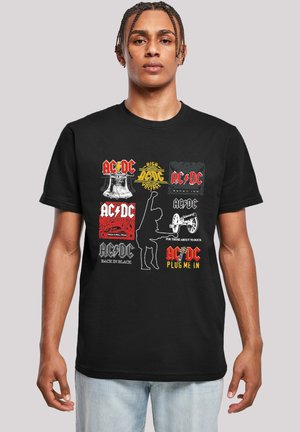 Black cotton t-shirt featuring multiple AC/DC logos in red, yellow, white, and gray. Designs include a bell, lightning bolt, and rock silhouettes.