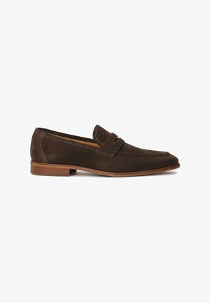 Mokoiset mokka loaferit, joissa on litteä korko, klassinen siluetti ja koristeellinen yläraita. Pohja on vaaleanruskea ja hieman kohotettu.