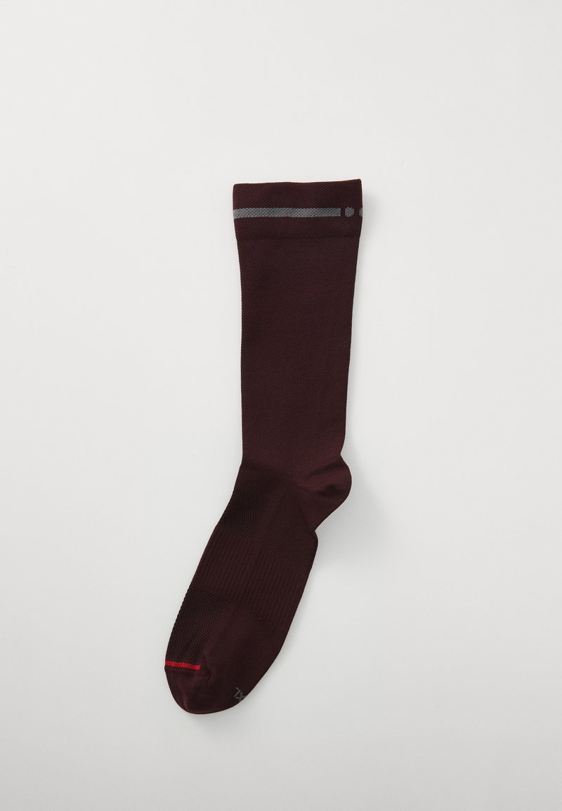 Meia até ao joelho em bordeaux com uma textura suave, apresentando riscas cinzentas no topo e um detalhe vermelho na ponta. Palmilha estruturada para conforto.