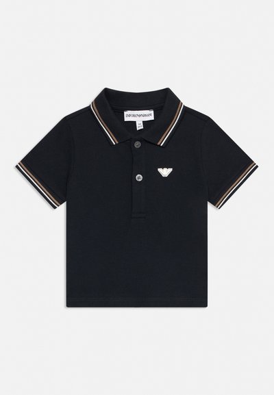 Polo nera a maniche corte con rifiniture a righe marroni e bianche su colletto e maniche e piccolo logo bianco sul petto sinistro.