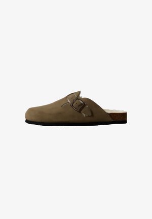 Brown suede slip-on clog with a cork midsole, adjustable buckle strap, and a soft textured lining. Flat black outsole.