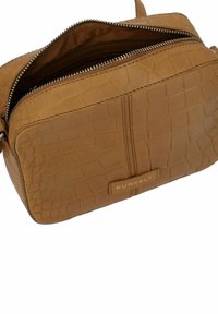 Borsa a tracolla in pelle con stampa coccodrillo di colore tan, con hardware argento e chiusura a zip, caratterizzata da una texture liscia e un accentuato marchio.