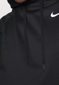 Hoodie noir en tissu lisse avec une capuche, arborant un logo Nike blanc et des cordons de serrage noirs. Design minimaliste, sans motifs ni accents.