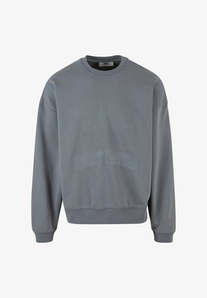Hallituspruun puuvillane sweatshirt ümmarguse kaelusega, pehme tekstuuriga ja esiküljel kontrastse värviga broderitud "Trust Issues". Mugav lõige.