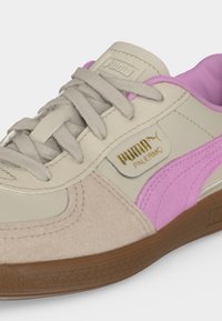 Μπεζ και ροζ sneaker Puma Palermo με μπεζ κορδόνια, χρυσό λογότυπο Puma και σόλα από καουτσούκ, ορατή από πλάγια πλευρά.