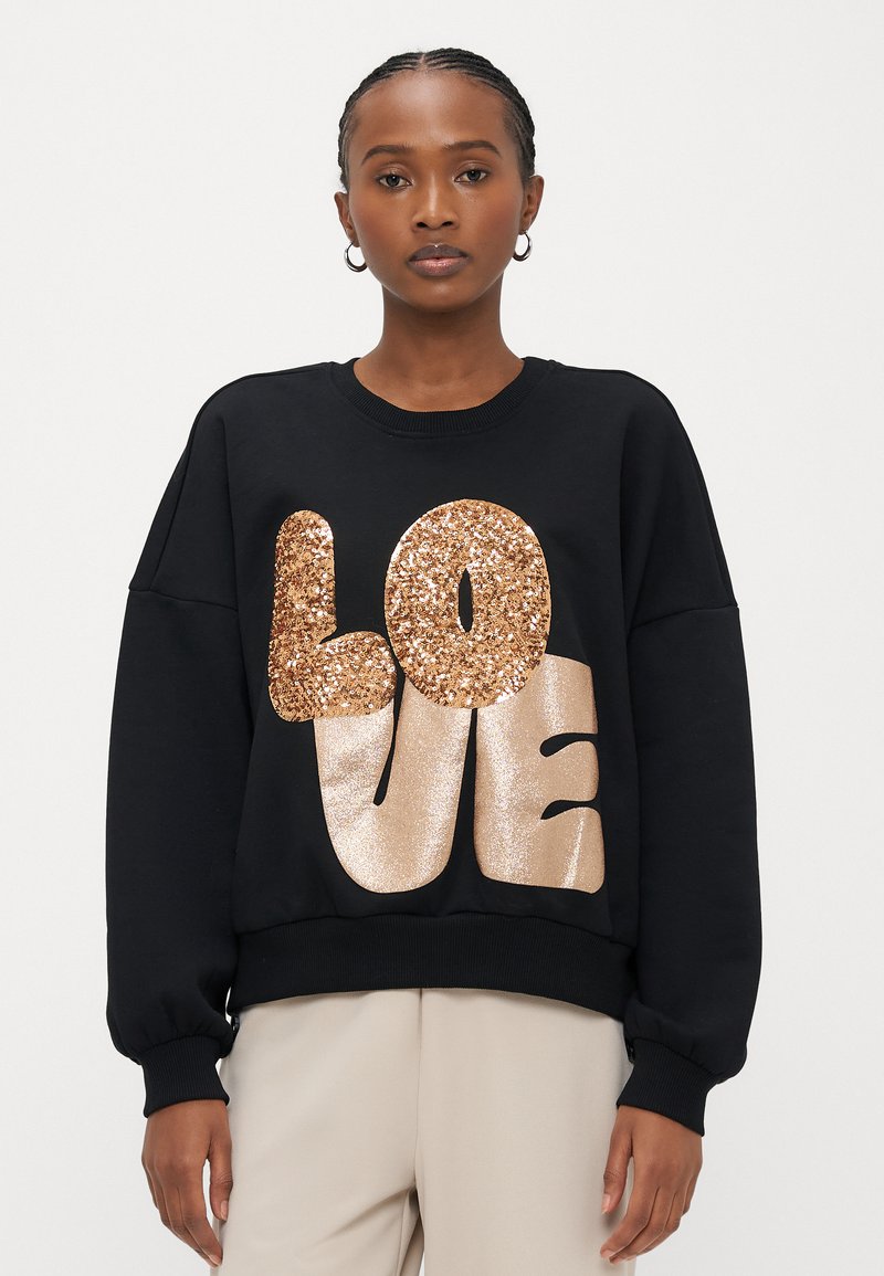 Sweatshirt preta com texto "LOVE" em glitter dourado oversized. Apresenta gola redonda e mangas com punhos, feita de tecido macio.