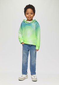 Groene en blauwe gradient hoodie met een voorzak en logo; gecombineerd met lichtblauwe jeans en witte sneakers. Gladde stof en relaxte pasvorm.