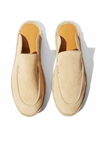 Scarpe slip-on beige in suede con punta arrotondata e cuciture visibili. Presentano una suola in stile espadrilles intrecciato e una fodera interna liscia.
