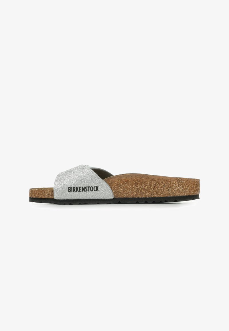Infradito con una tomaia glitterata argento, suola intermedia in sughero e suola esterna in gomma nera. Presenta una larga fascia con il marchio "BIRKENSTOCK".