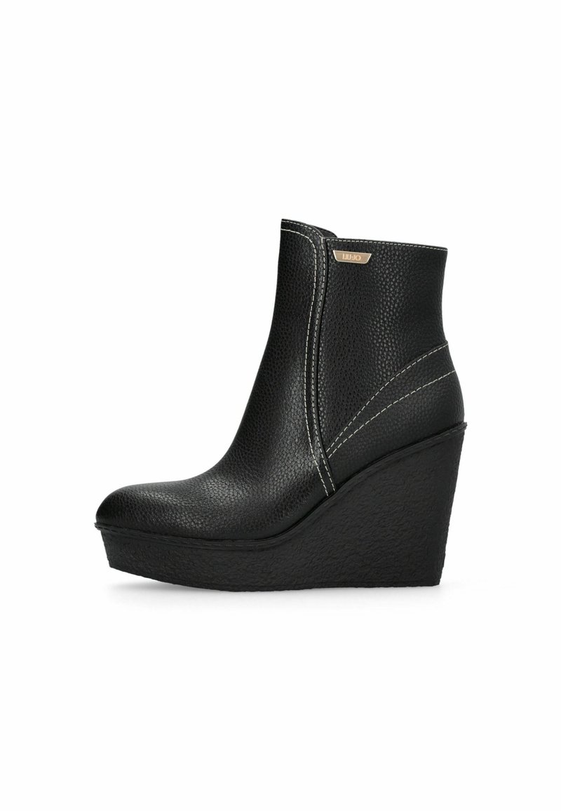 Botine negre cu toc wedge, realizate din piele texturată, cu vârf rotund, accente de cusături pe lateral și un detaliu subtil cu logo metallic.