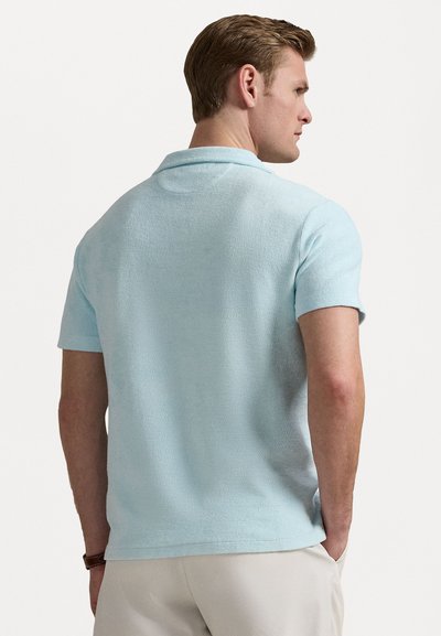 Lichtblauw polo shirt van een gestructureerde stof, met een opstaande kraag en korte mouwen. Het ontwerp heeft een regular fit en minimale details.