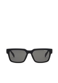 Lunettes de soleil rectangulaires noires avec des montures épaisses et des verres foncés, montrant le petit logo "Chopard" sur le verre supérieur droit.