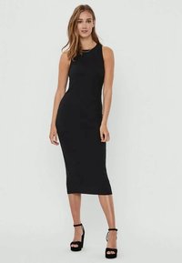 Black sleeveless midi dress with a fitted silhouette. Smooth fabric, round neckline, and side slits. Worn with black platform heels.