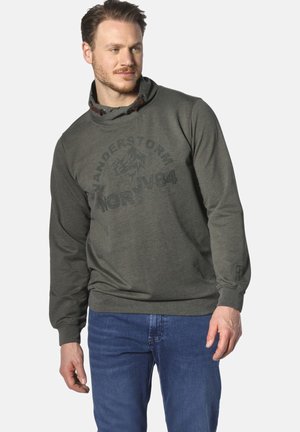 Dunkelgrünes Kapuzensweatshirt mit strukturierter Oberfläche und einem bedruckten Logo. Es hat Kordeln und einen lässigen Schnitt und wird mit blauen Jeans kombiniert.