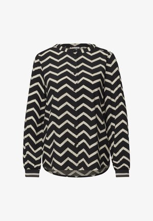 Bluzka w czarno-białe zygzaki z okrągłym dekoltem, długimi rękawami, z zapięciem na guziki oraz elastycznymi mankietami. Miękka tekstura materiału.